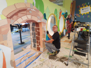 Artist William Hernandez working on a mural in Cornelius Library's Reser's Childrens Center